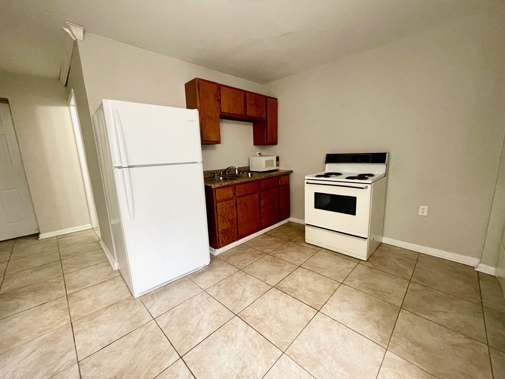 a kitchen with a refrigerator and a stove and a sink