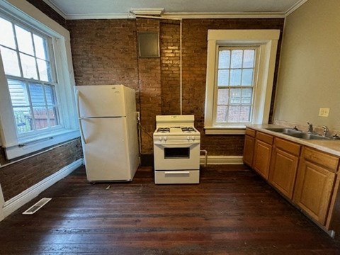 an empty kitchen with a stove and a refrigerator