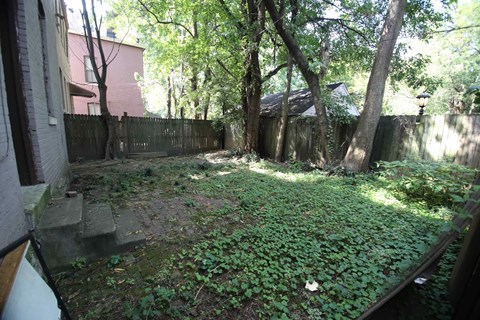 the backyard of a house with a fence and trees