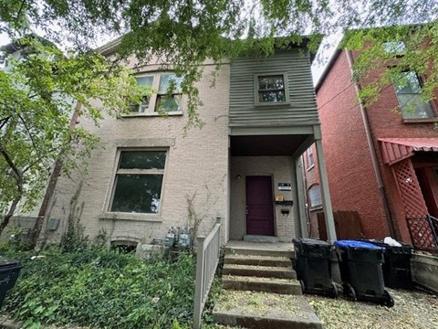 a brick house with a purple door and stairs