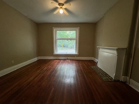 a empty room with a ceiling fan and a window