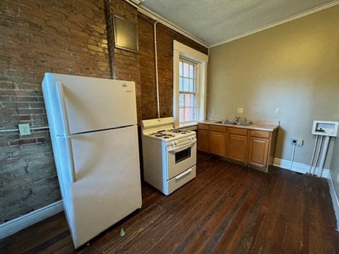 an empty kitchen with a white refrigerator and a stove