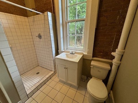 a bathroom with a toilet and a sink and a window