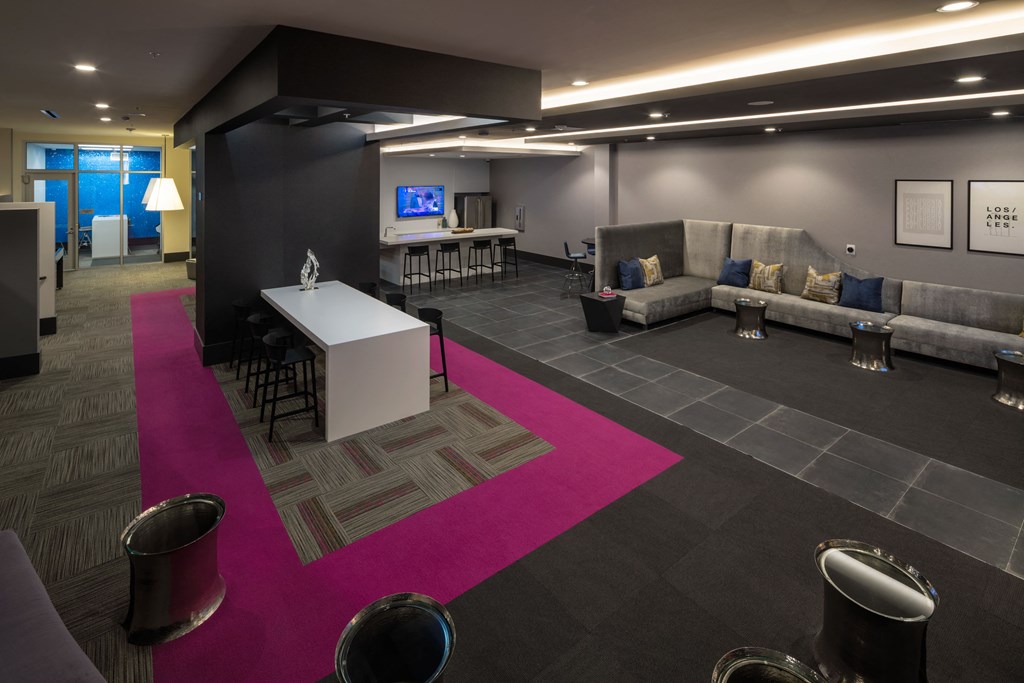 a room with couches a table and chairs and a pink rug