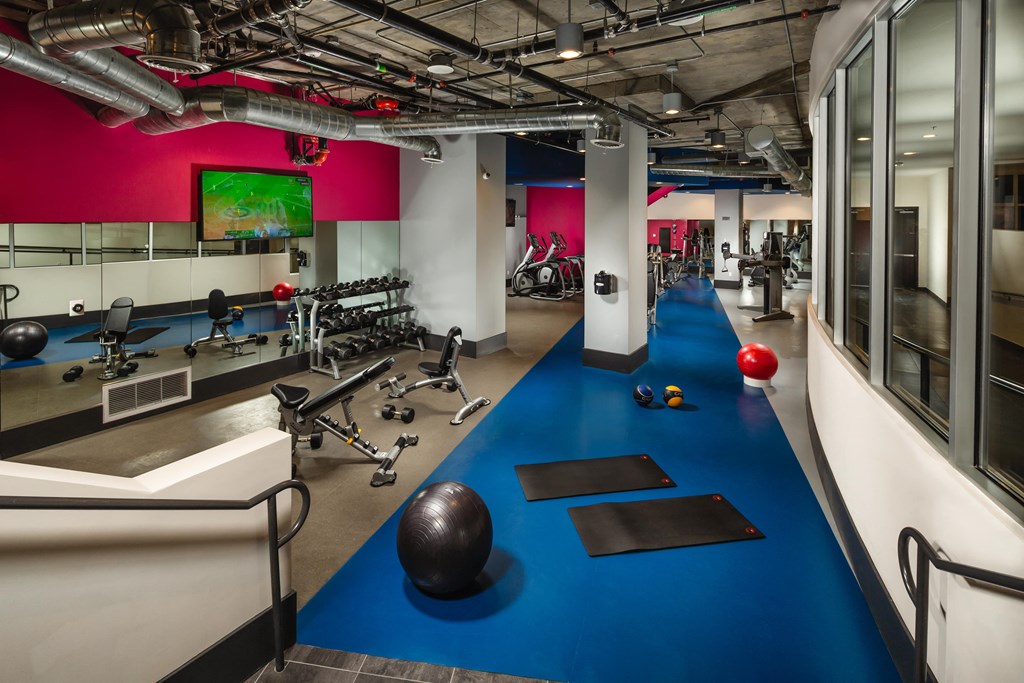 a gym with a bowling ball and weights on a blue floor