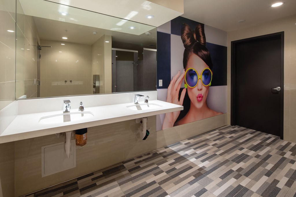 a bathroom with a large picture of a woman wearing sunglasses