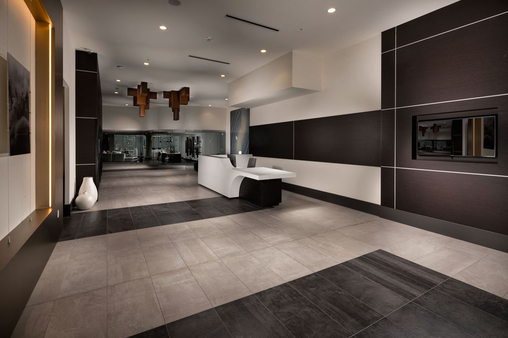 the lobby of a hotel with a reception area and a white desk