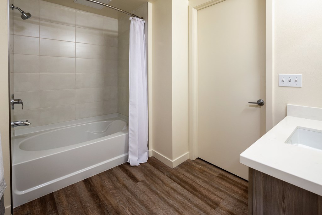 a bathroom with a tub and a sink and a mirror