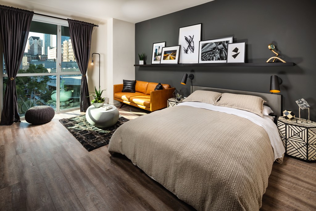 a bedroom with a bed and a couch and a window