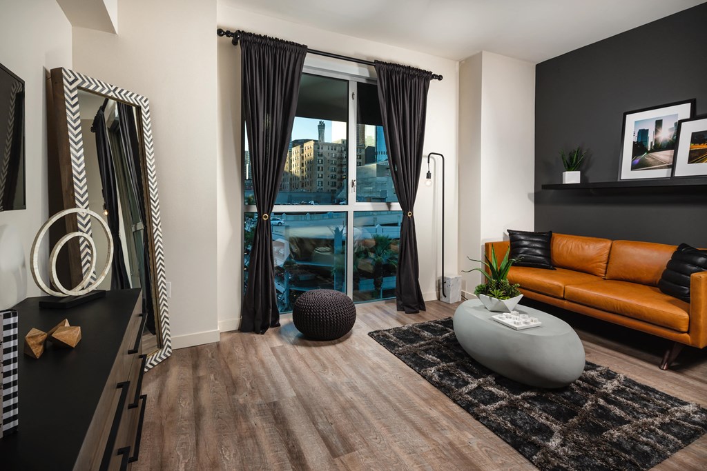 a living room with a leather couch and a large window