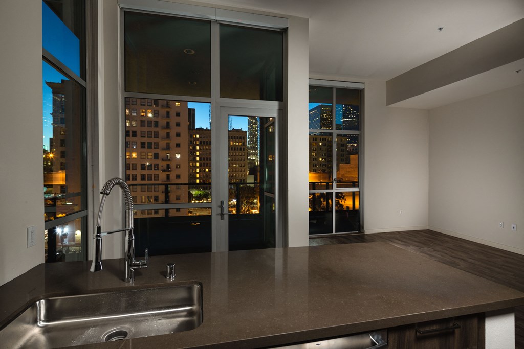 a kitchen with a sink and a view of the city at night