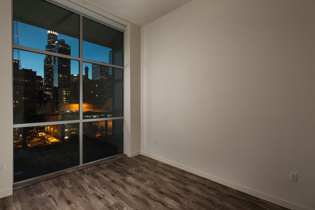 a living room with a large window overlooking a city at night