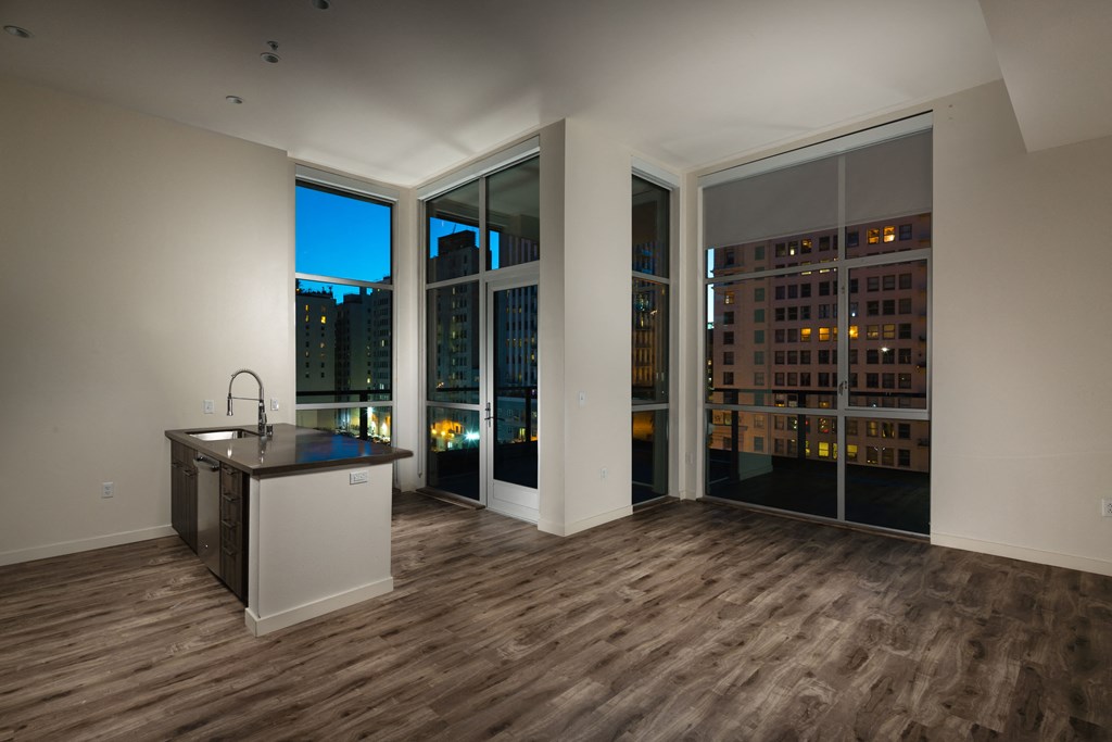 a living room with a kitchen and a view of the city at night