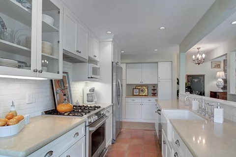 a white kitchen with a stove and a sink