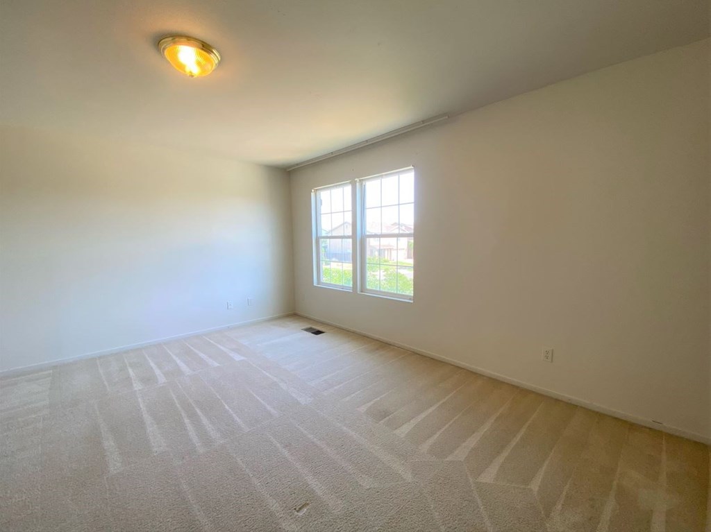 the living room of an empty house with a window