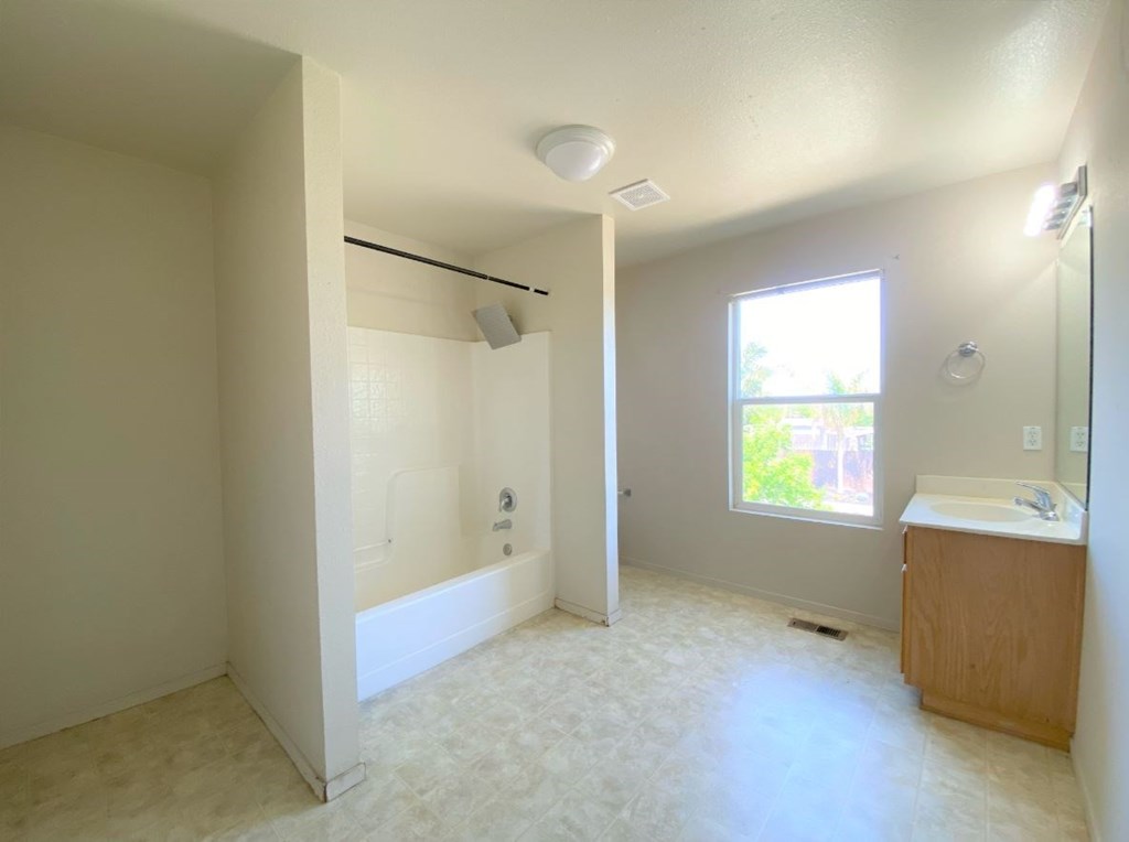 a bathroom with a tub and a sink and a window