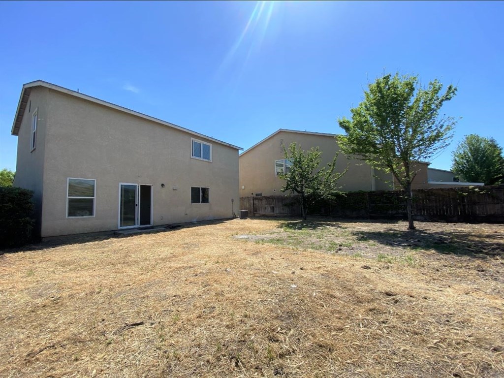 the backyard of a house with a yard and a tree