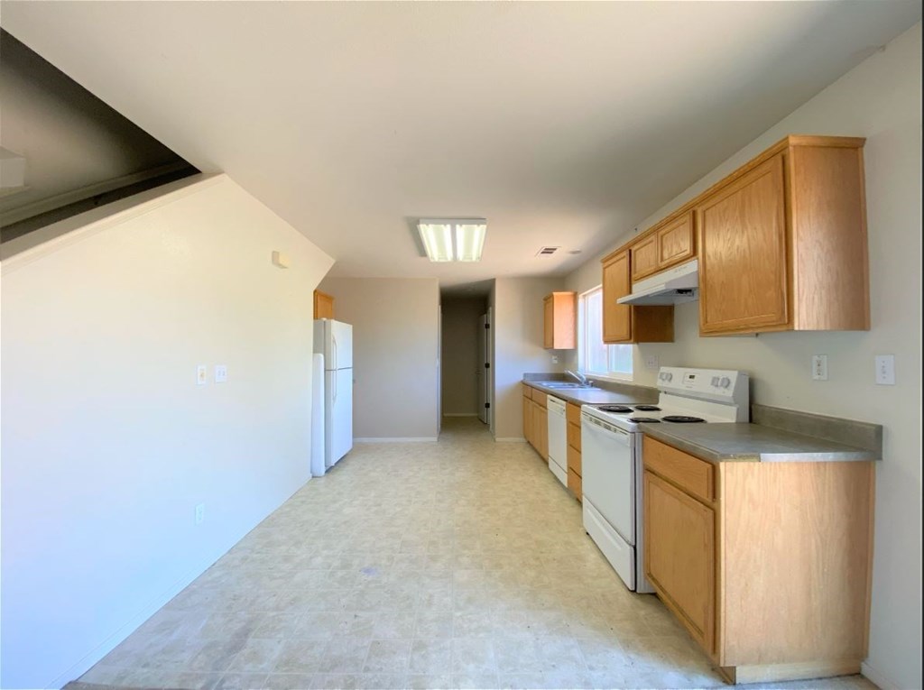 a kitchen with white appliances and wooden cabinets