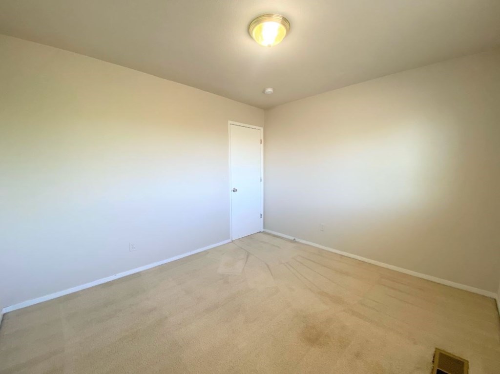 a empty room with white walls and a wooden floor