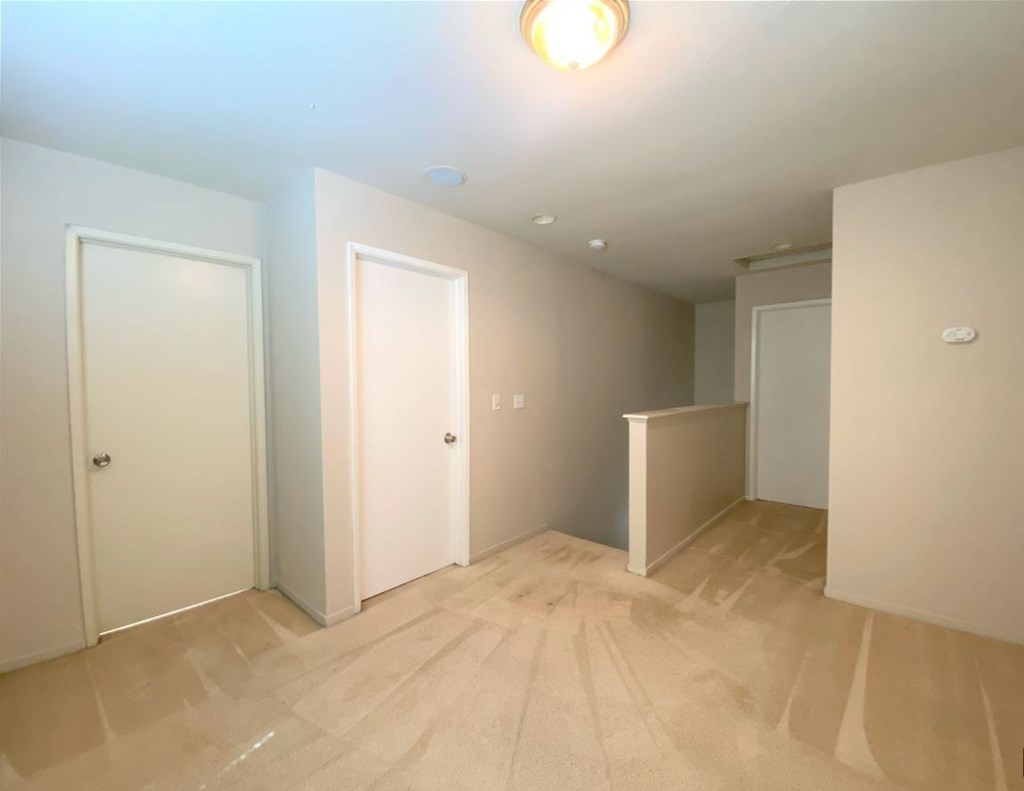 a empty room with white walls and wooden floors
