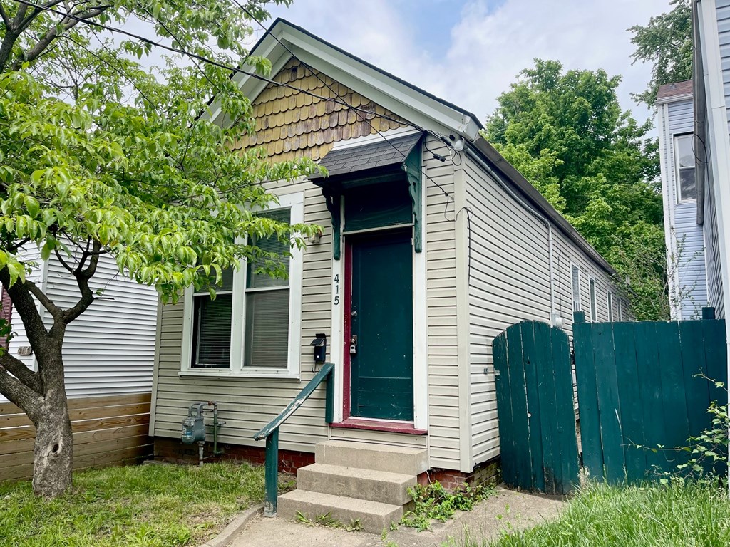A small house with a green door and a red step.