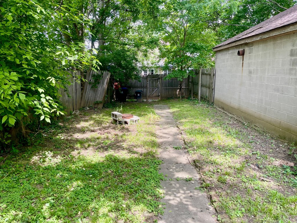 A backyard with a wooden fence and a shed.