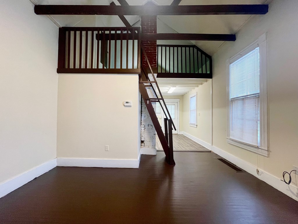 A room with a wooden staircase and white walls.