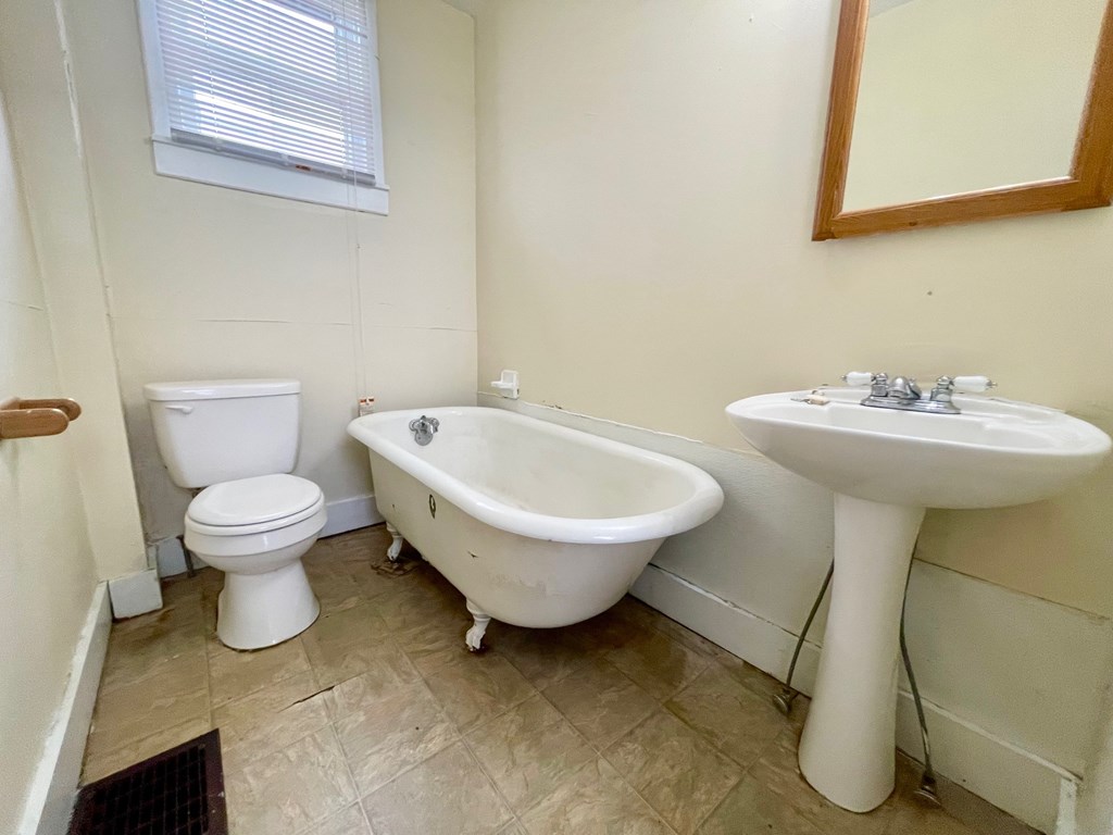 A white toilet sits next to a white sink in a bathroom.