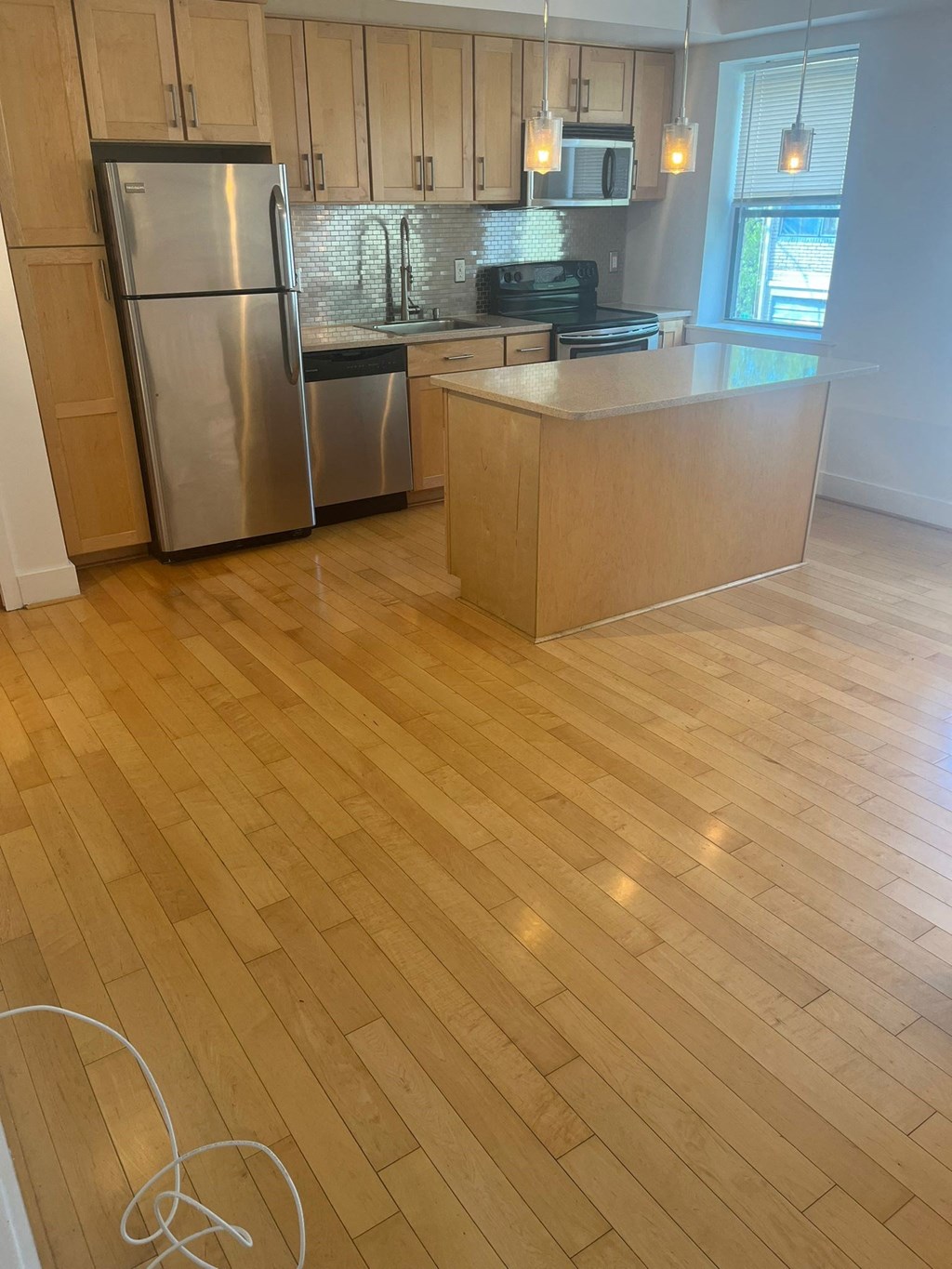a kitchen with wooden floors and stainless steel appliances