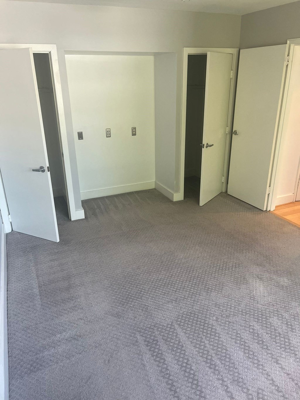 a living room with a carpeted floor and several doors