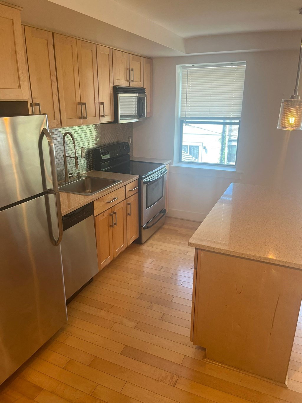 a kitchen with wooden floors and stainless steel appliances