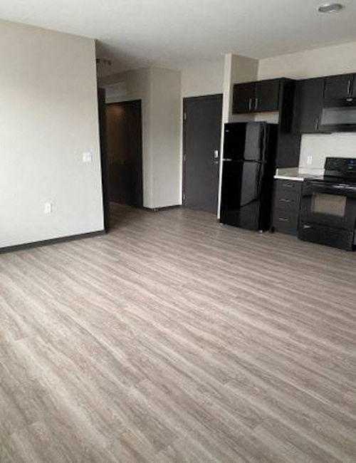 an empty room with a refrigerator and a stove