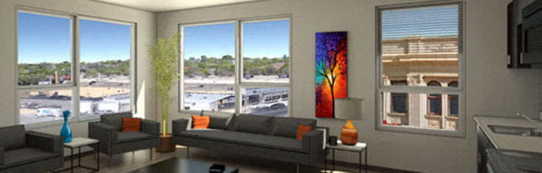 a living room with couches and a table and windows