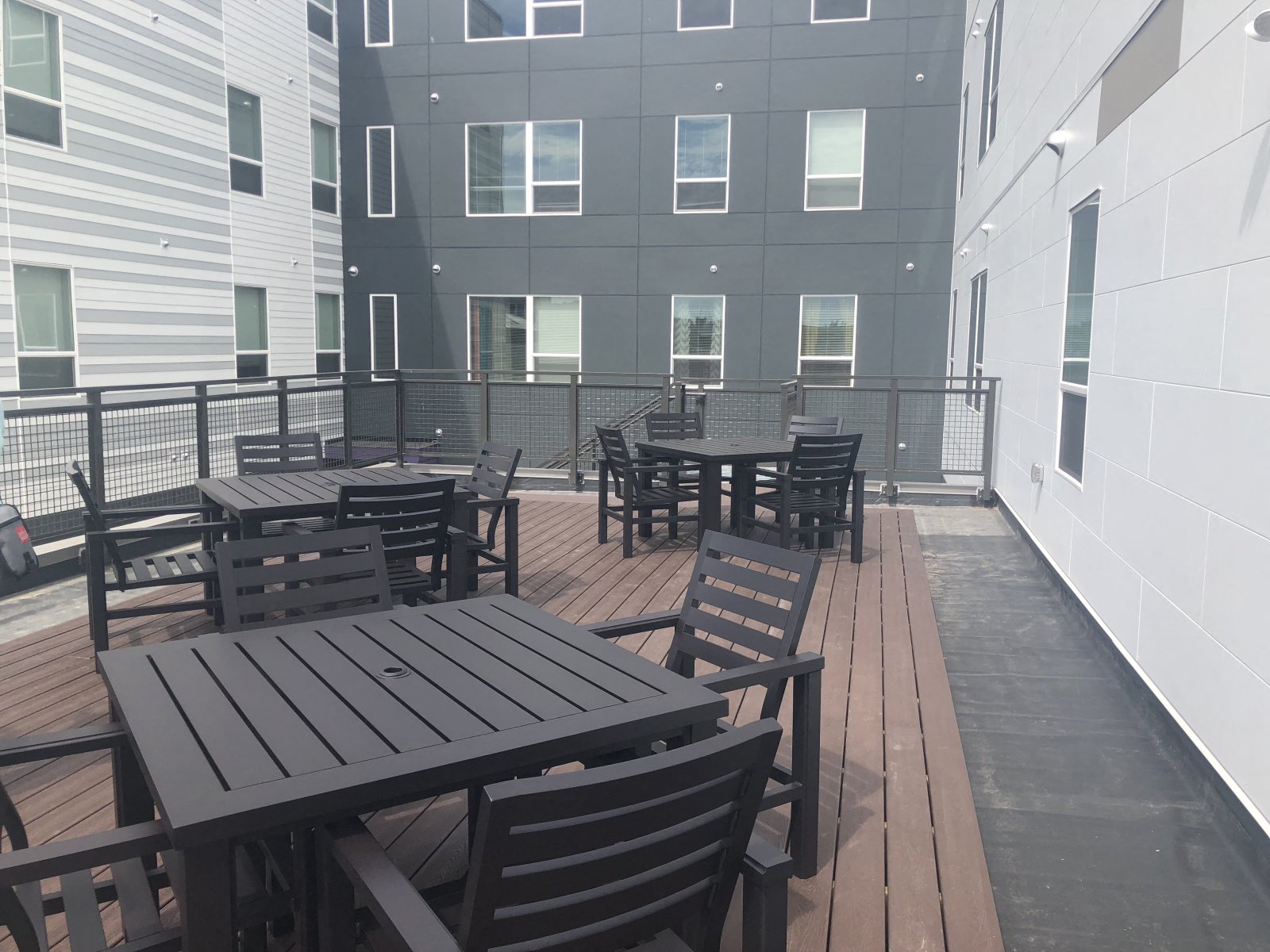 a large patio with tables and chairs on a balcony