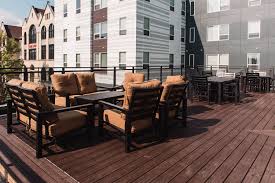a patio with wooden chairs and tables on a deck