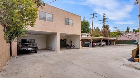A tan building with a black truck parked in front.