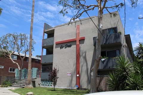 A large red cross is on the side of a building.