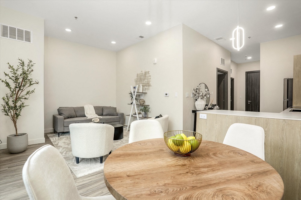 A modern dining room with a wooden table and white chairs.