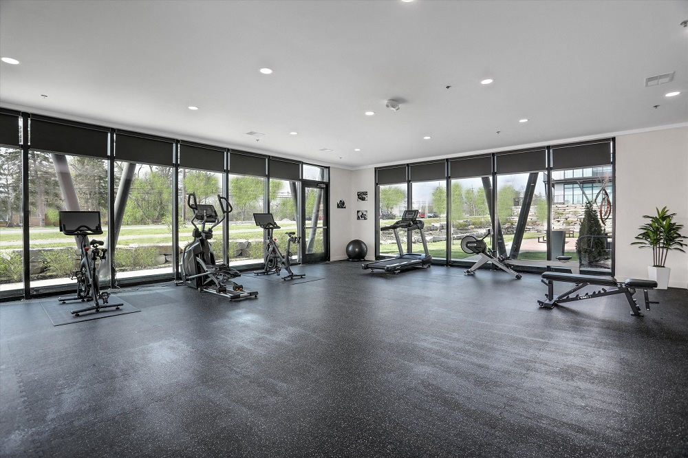 A gym with a row of exercise bikes and a bench.