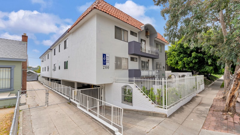 A white building with a red roof and a blue sign that says "200" on it.