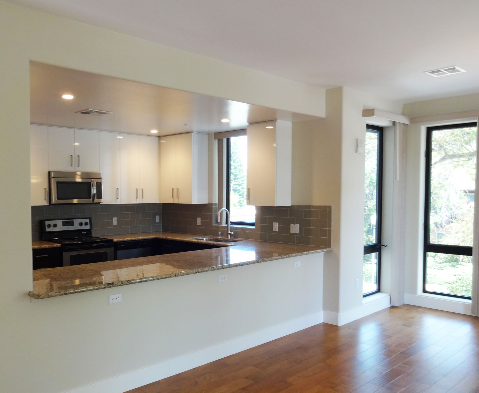 an empty kitchen with a granite counter top