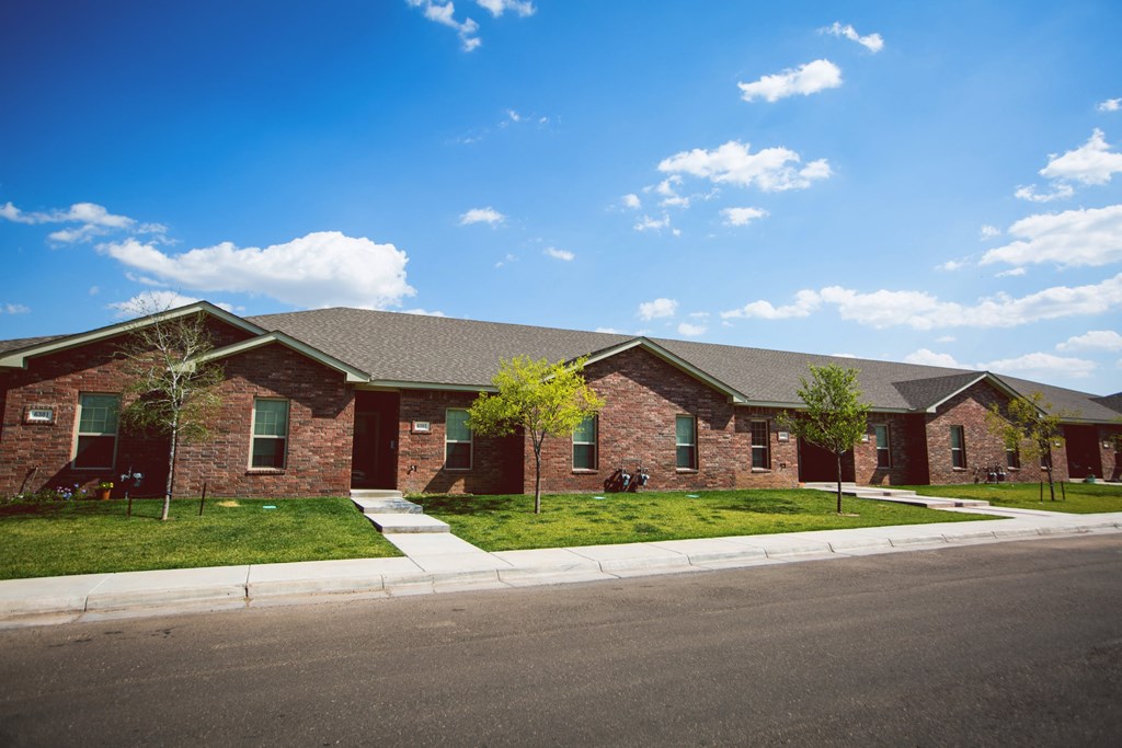 a red brick house with a street in front of it