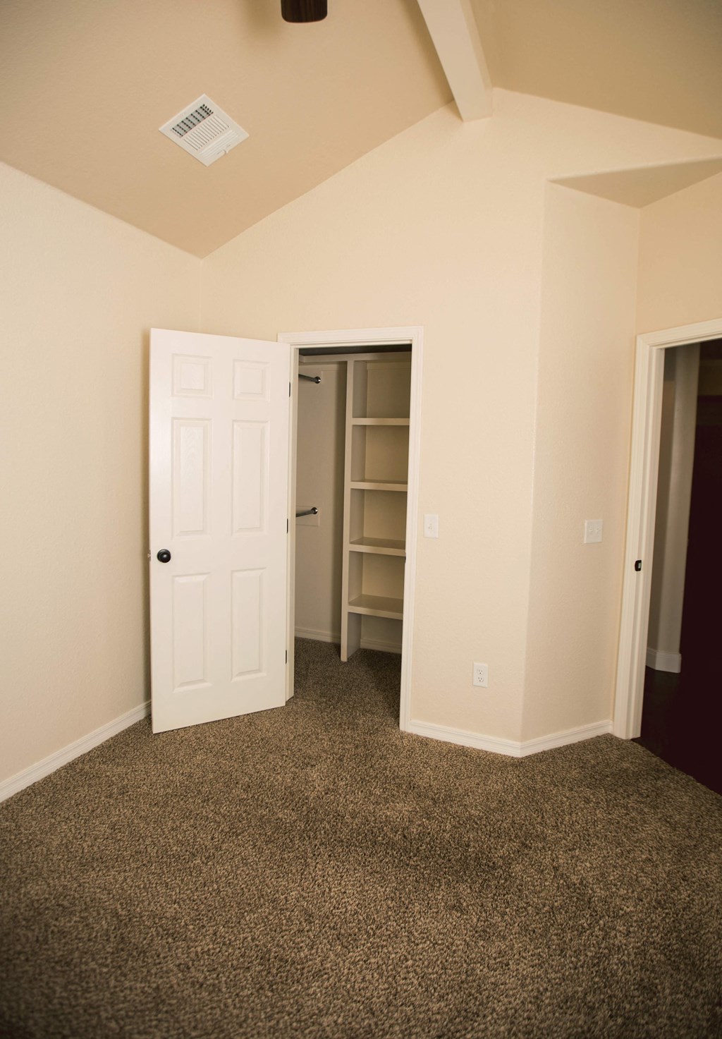 an empty room with a closet and a door to a closet