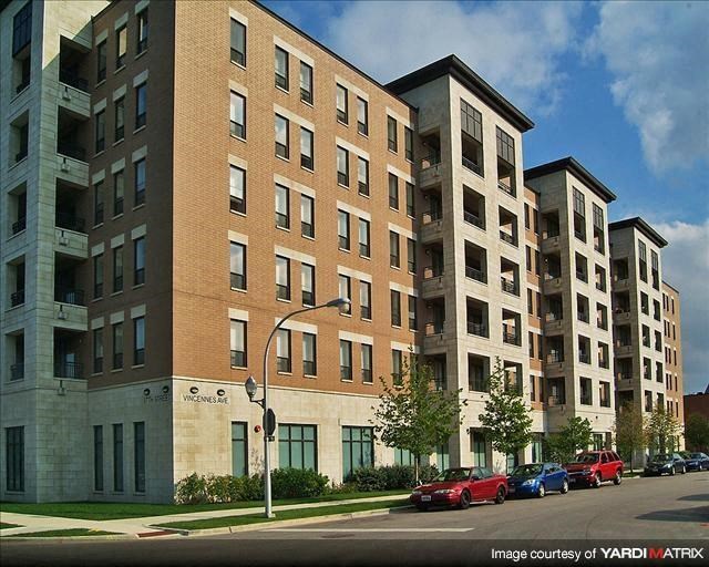a large apartment building with cars parked in front of it