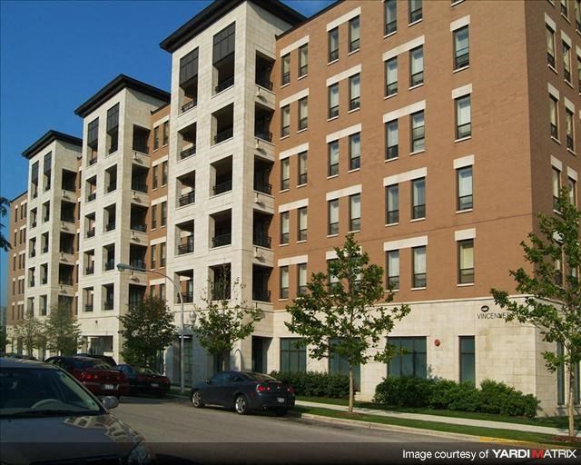 a large apartment building with cars parked in front of it