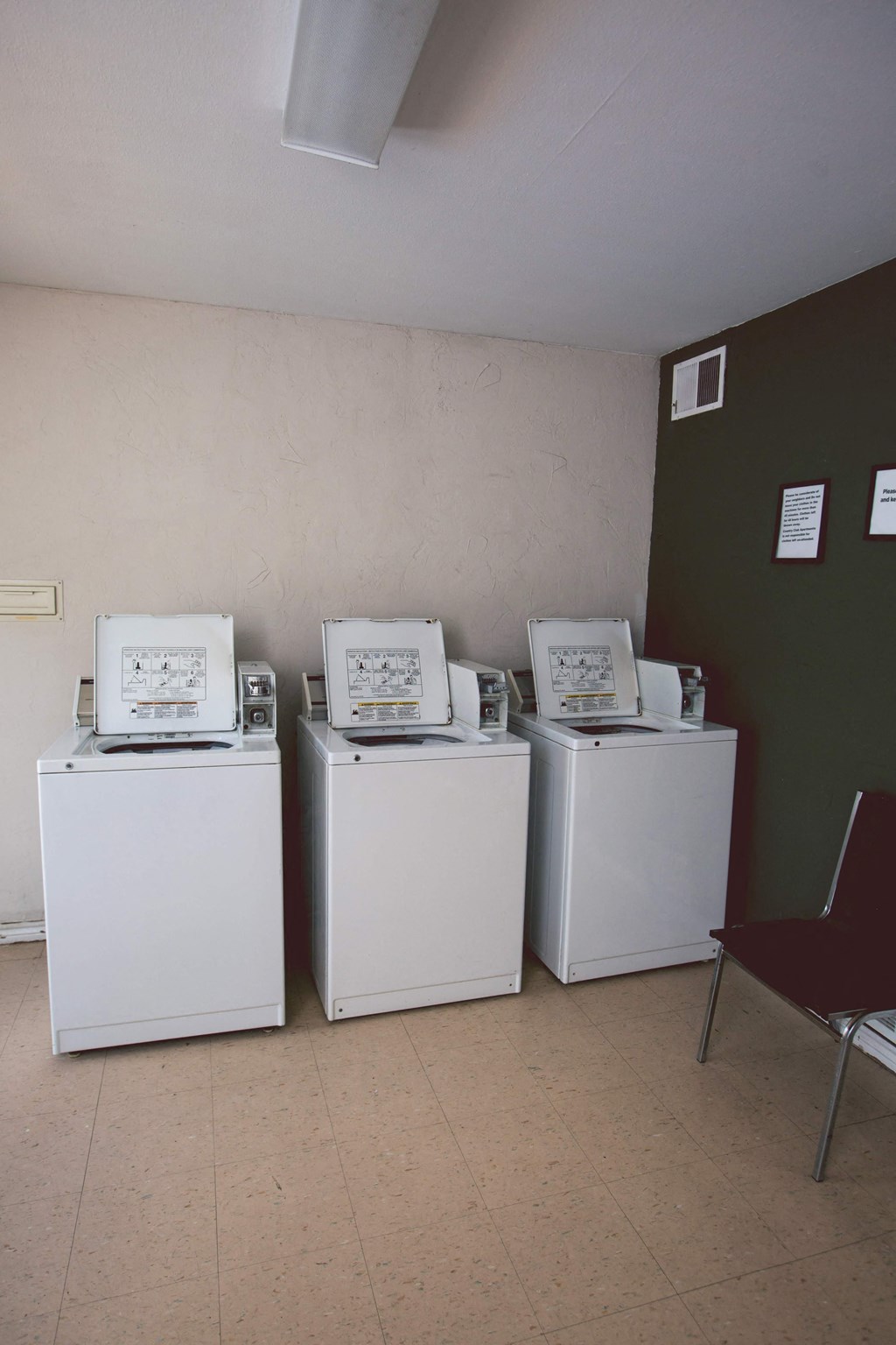 four washing machines are lined up next to each other in a room