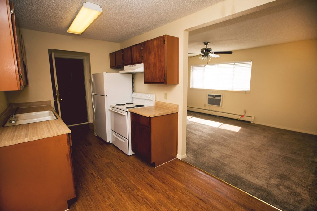 an empty kitchen with a stove and a refrigerator