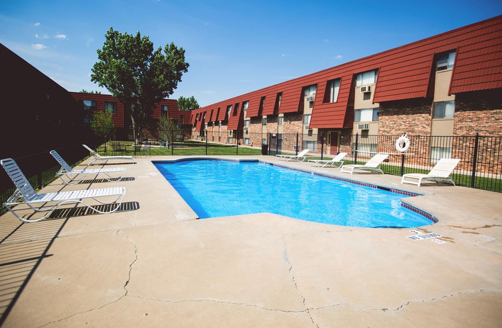 a resort style pool is in front of a red building