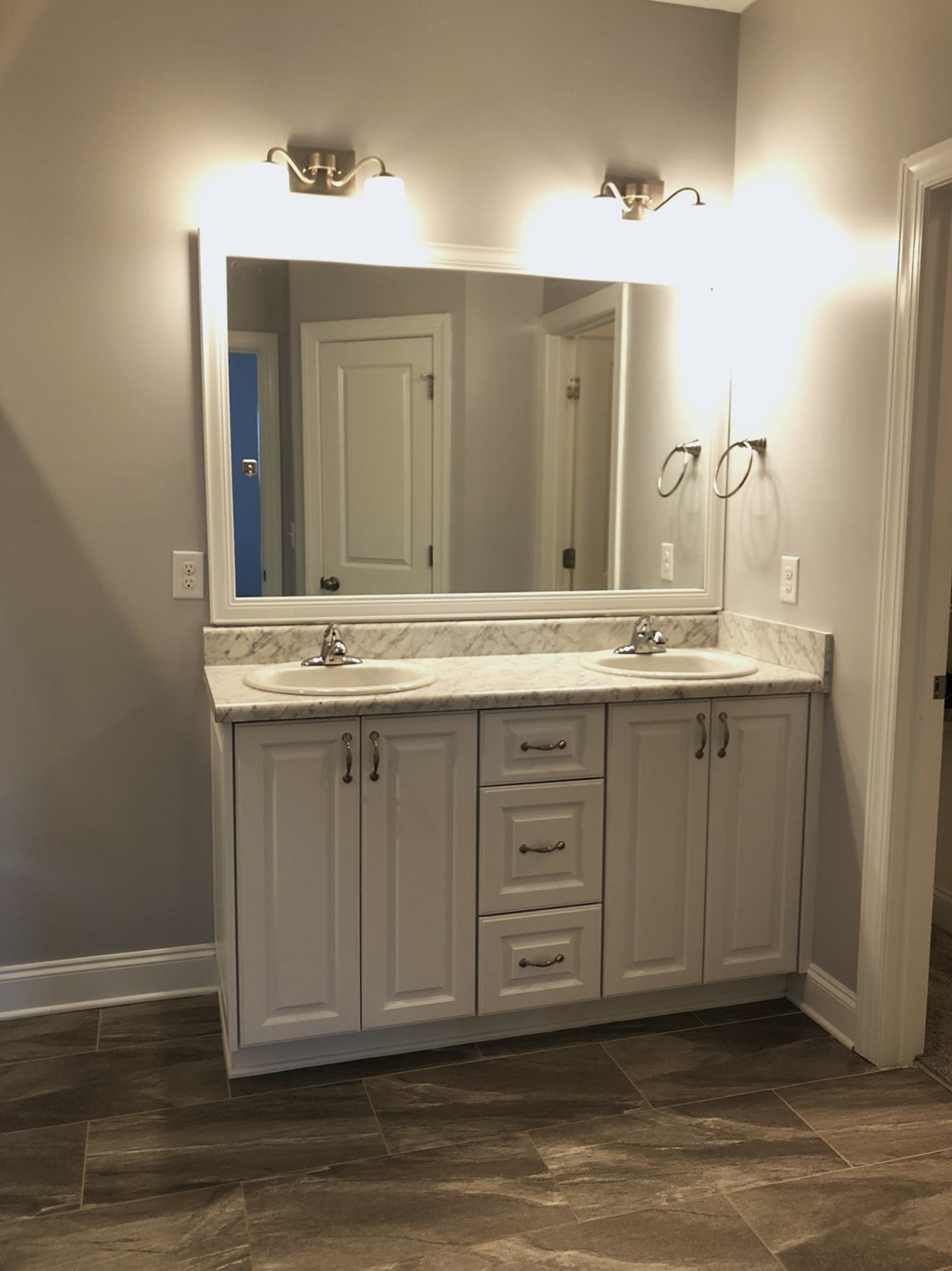 the master bathroom has a large vanity with two sinks and a large mirror