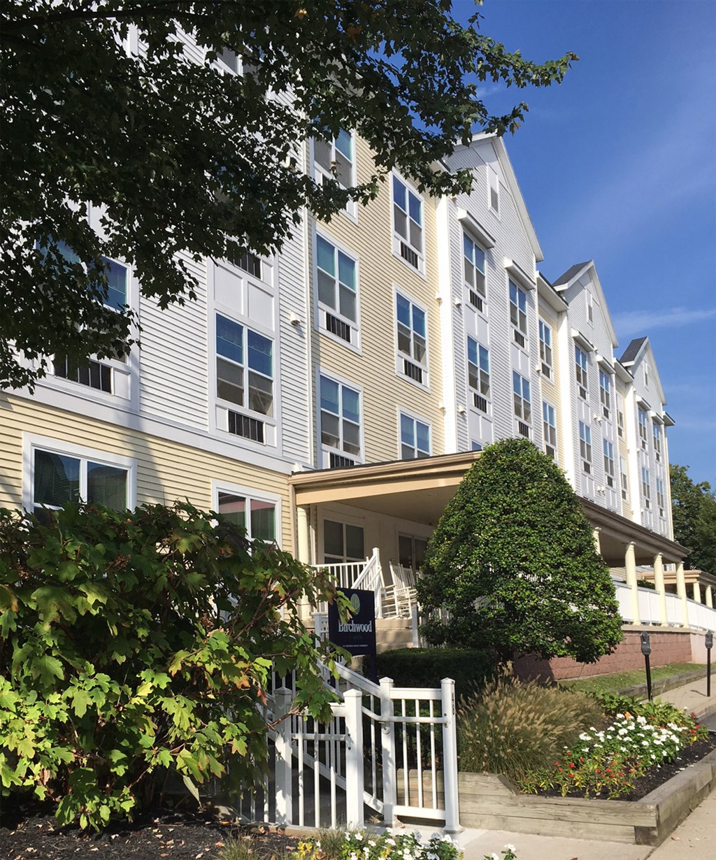 an apartment building with a white fence in front of it